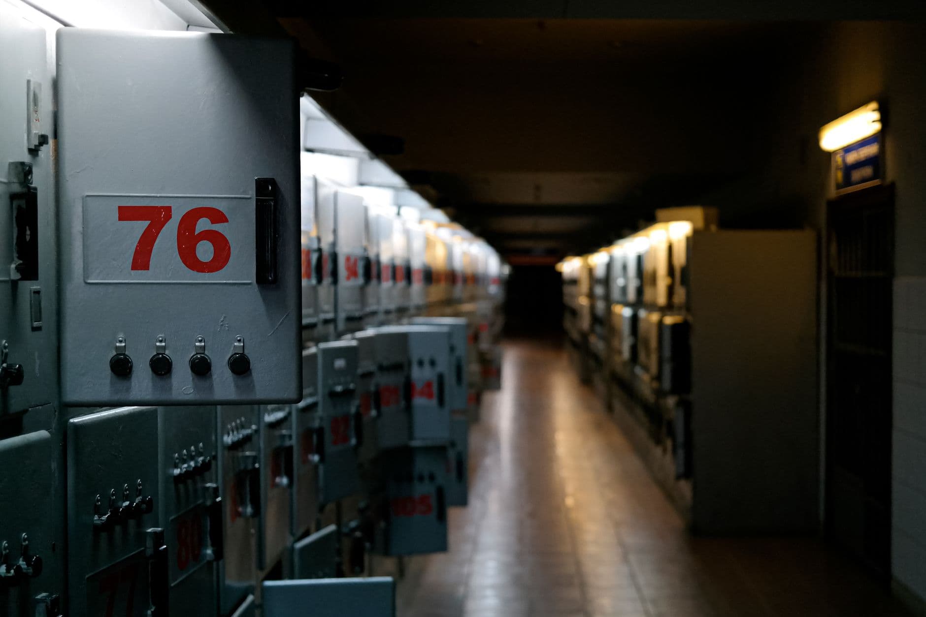 ელექტრო გამანაწილებელი ფარი ღია კარის უკან, დალაგებული ავტომატური ამომრთველებითა და ფერადი კაბელებით.